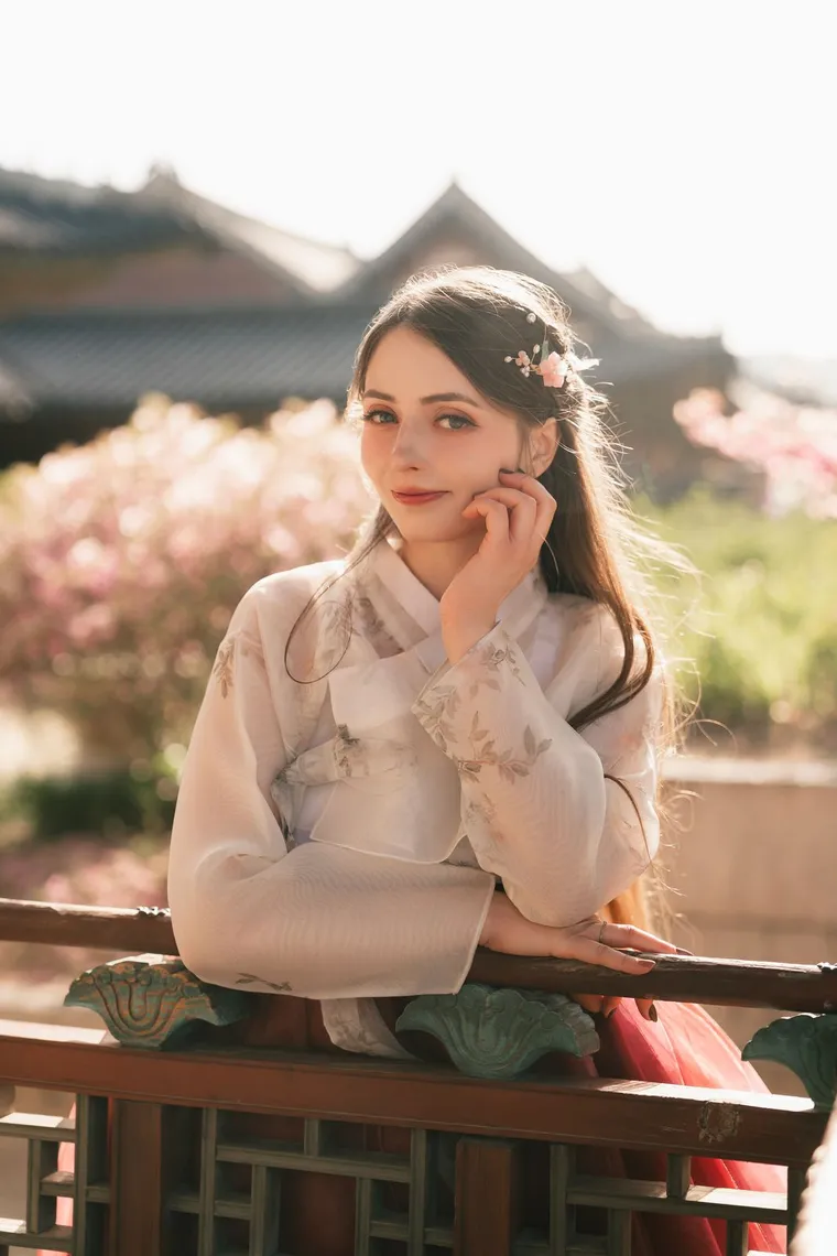 Woman in a white hanbok resting her chin on her hand at a palace railing